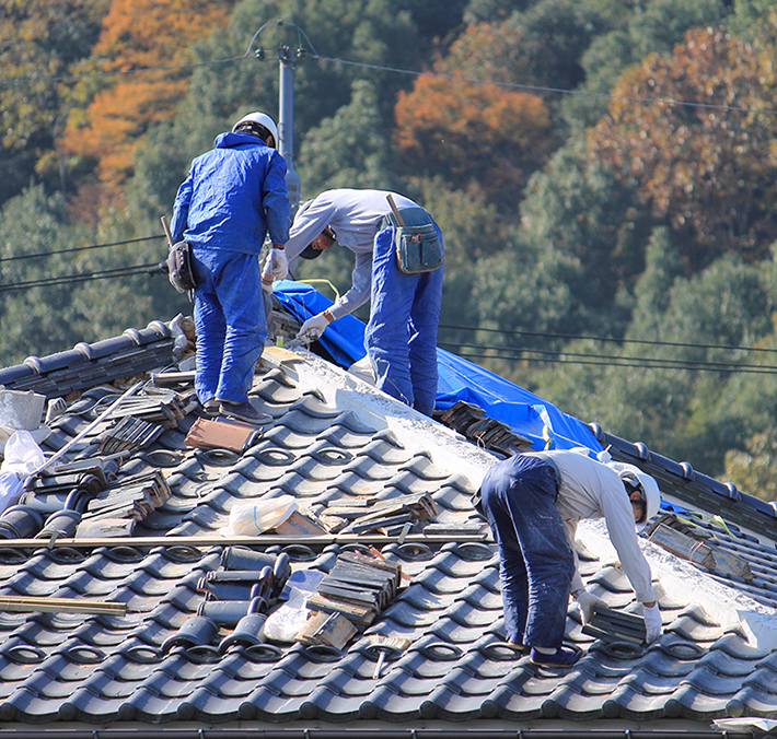 屋根工事をしている作業員の写真